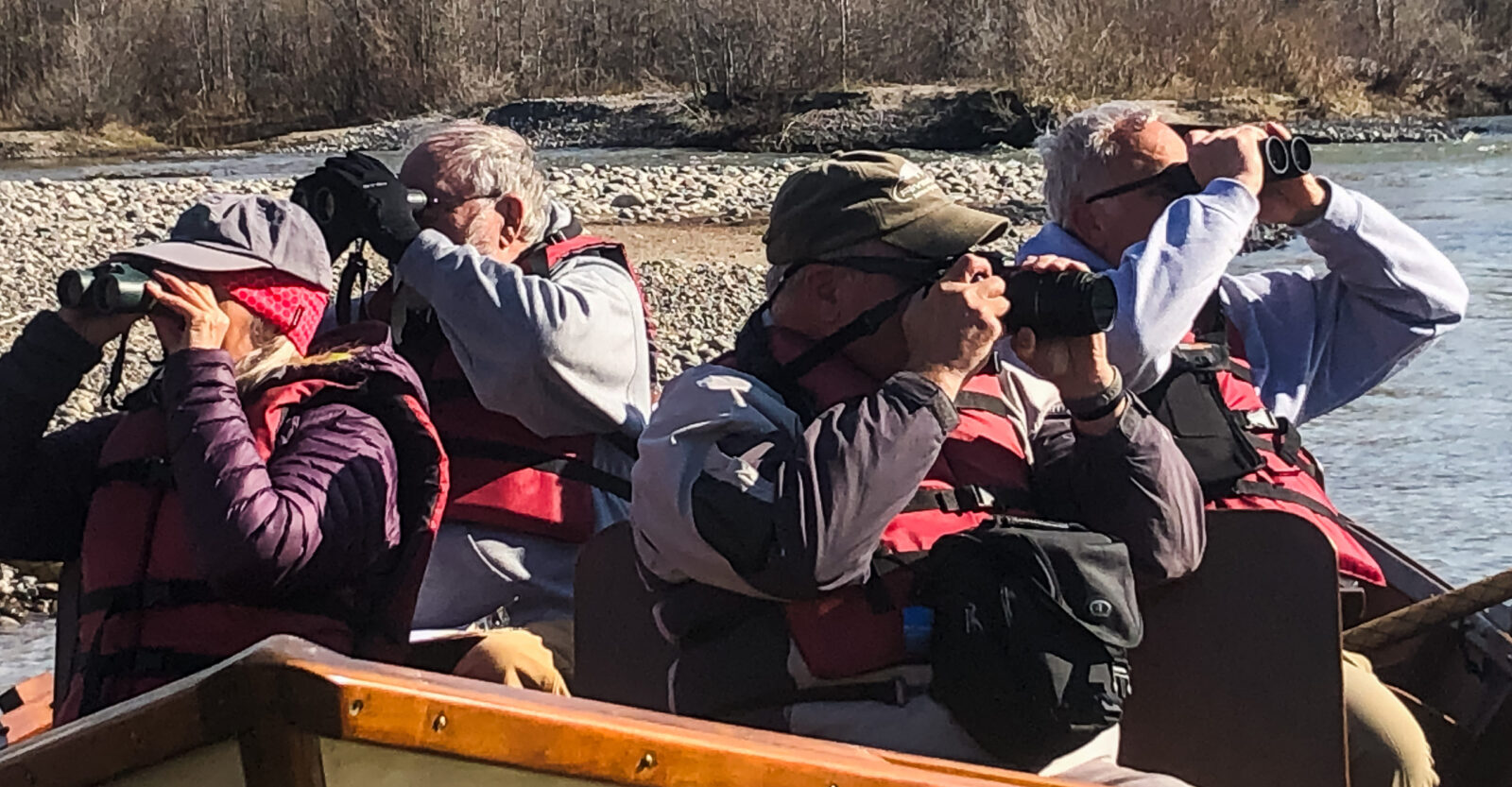 A Group Of People Look Through Binoculars While They Float On The Snake River In Jackson Hole Wyoming
