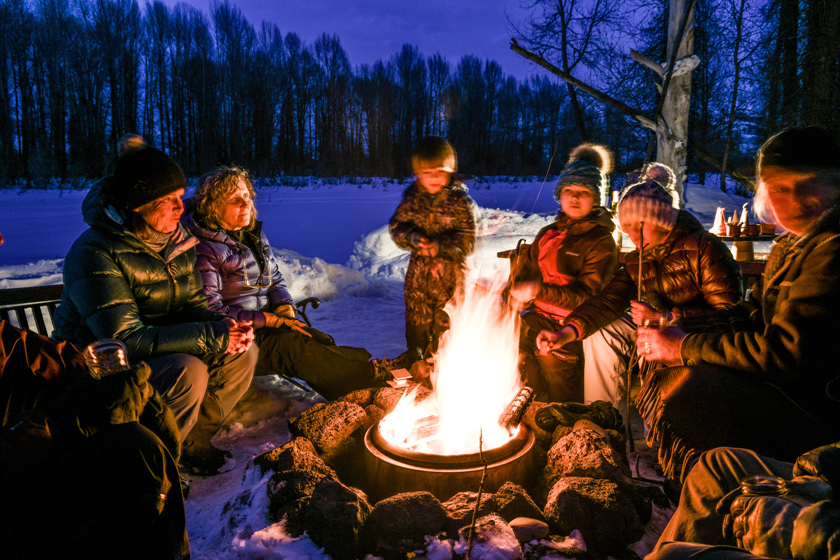 A Family Enjoys Roasting Smores Around A Winter Campfire At Tipi Camp In Jackson Hole Wyoming
