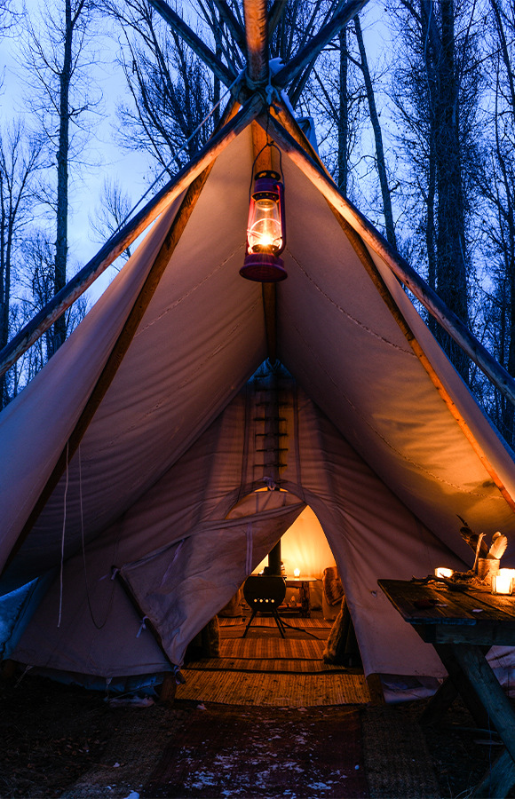 The Entrance To Tipi Camp Is Lit By Candles On A Cold Winter's Evening, Inviting Guests To Enter On A Jackson Hole Vintage Adventures Sleigh Ride
